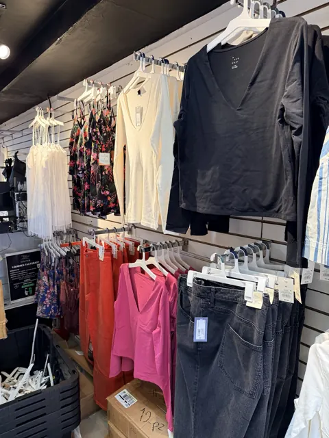 Exhibición de tops, jeans y prendas casuales de mujer en Outlet de 99